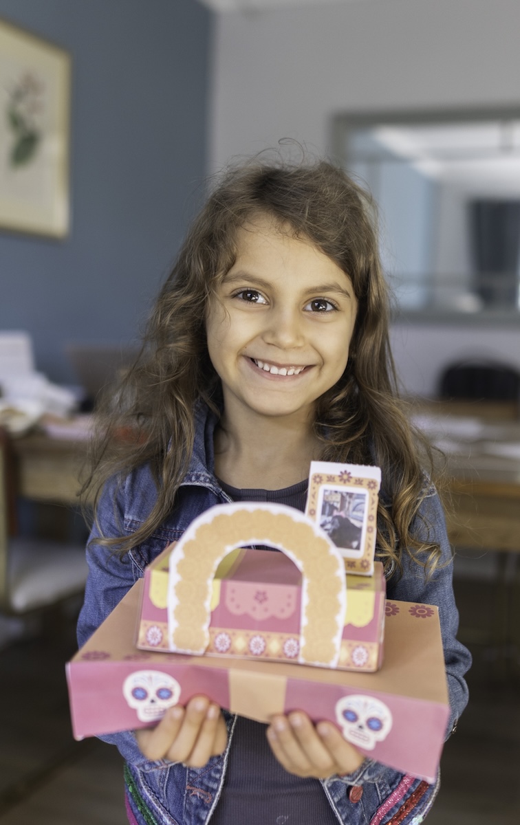 Children lighting Día de Muertos lanterns from the ofrenda kit